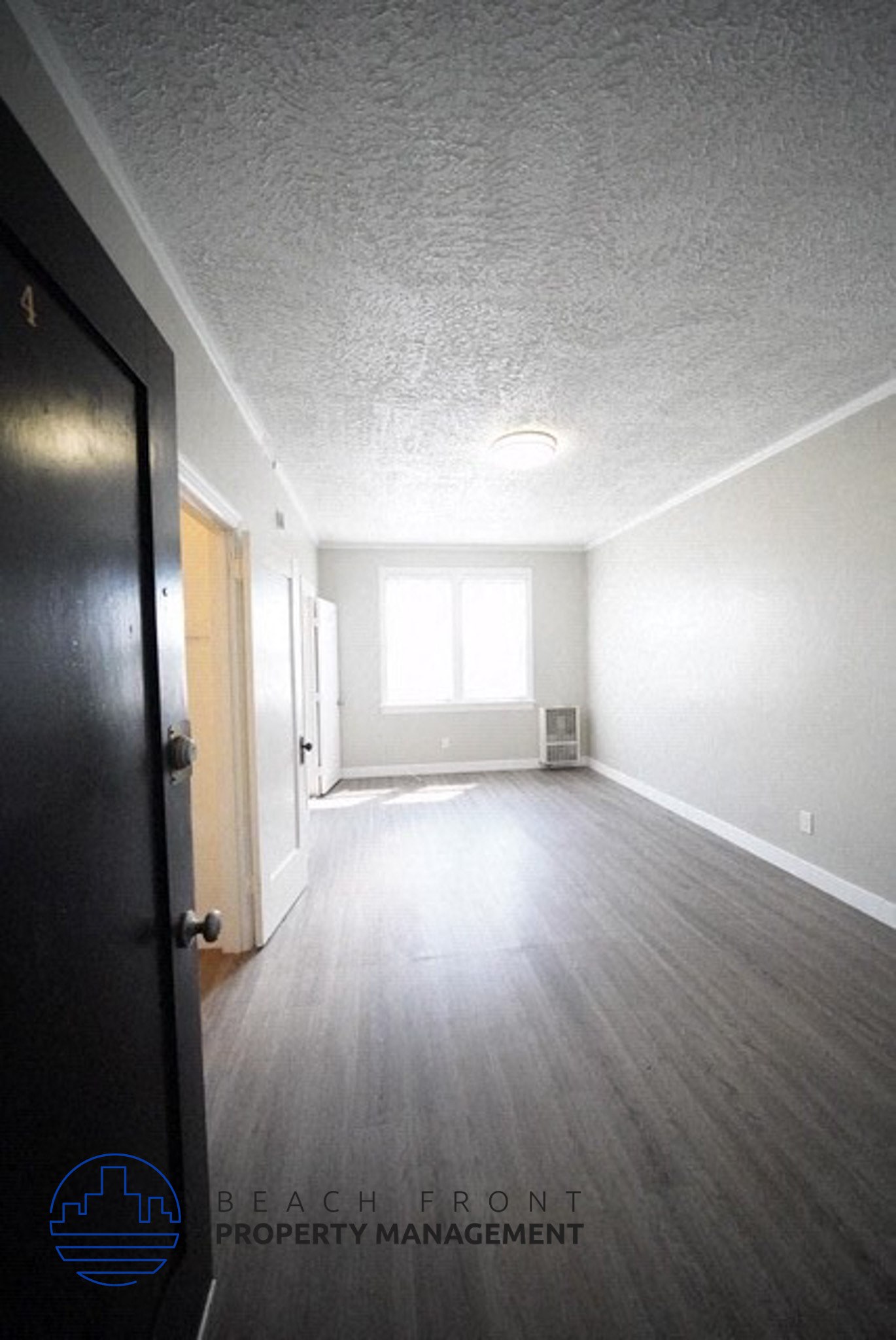 an empty room with white walls and a wood floor